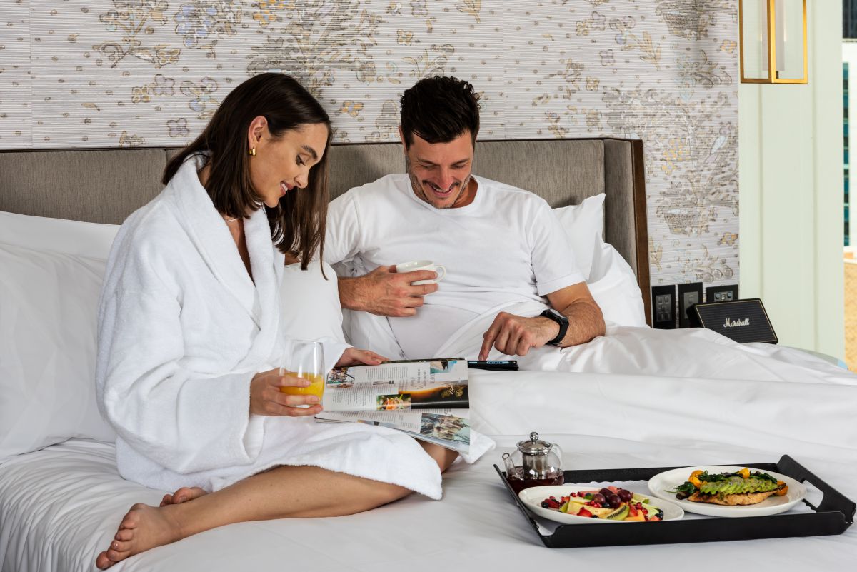 Couple relaxing with breakfast in InterContinental King bed